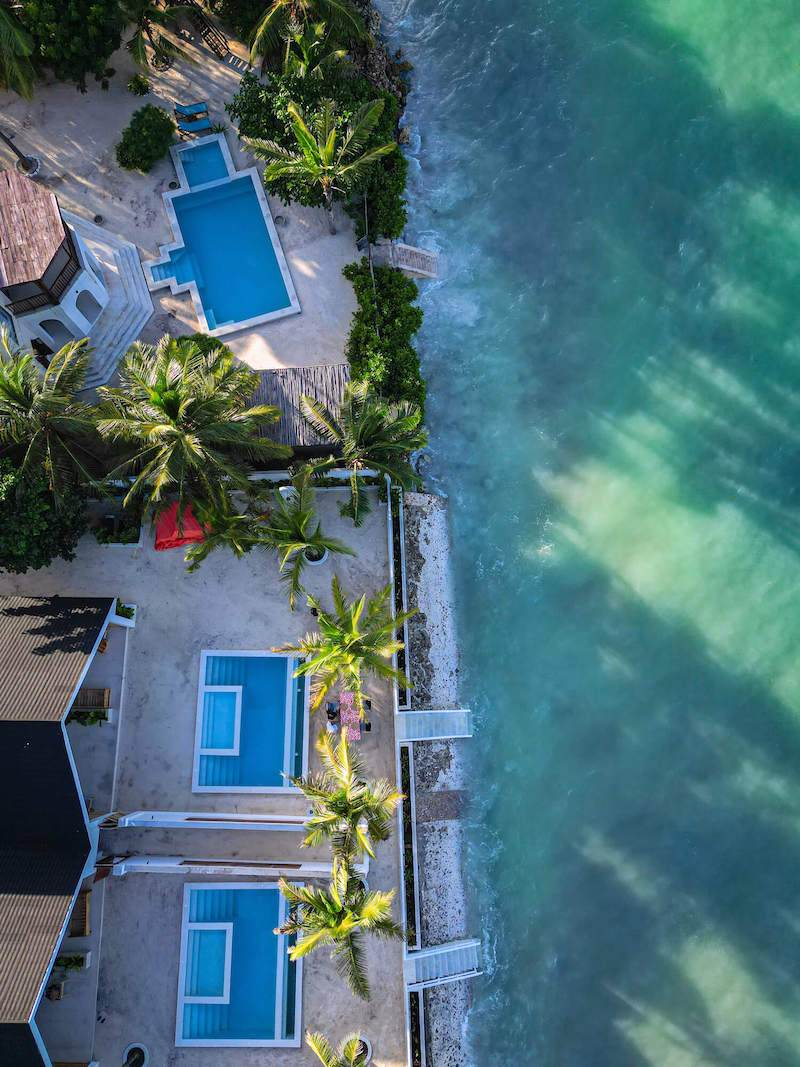 Aerial view of the Solymar villas with their pools next to the turquoise ocean