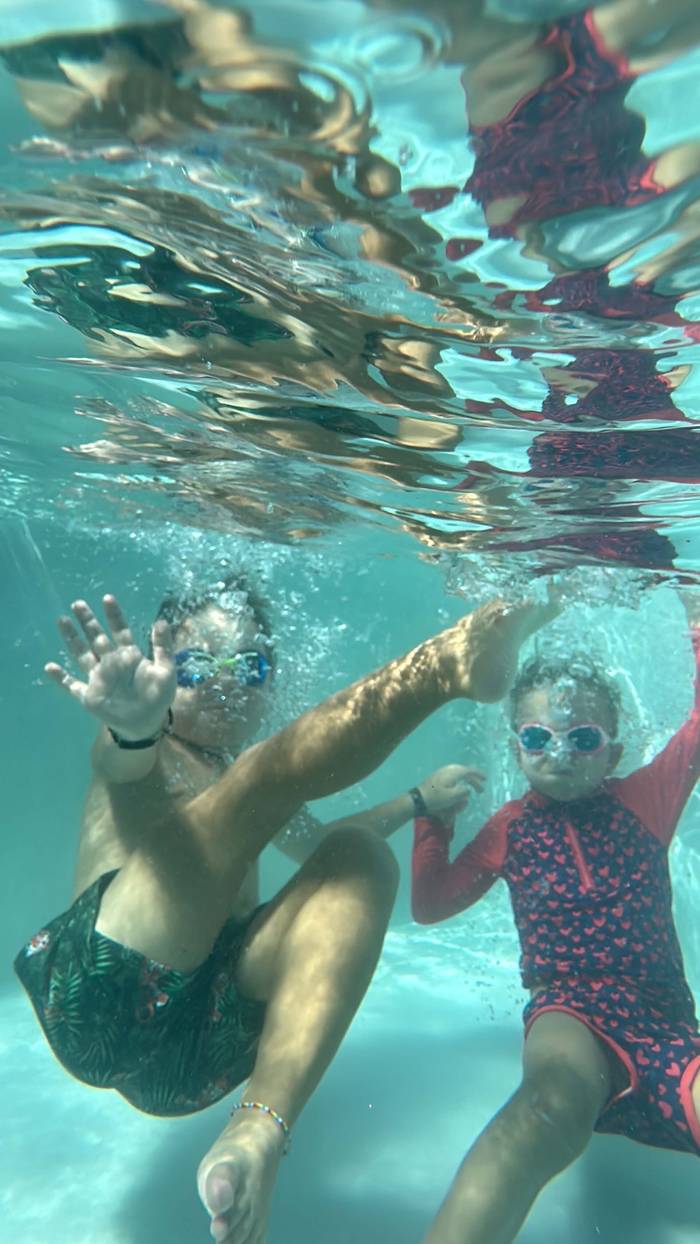Kids swimming underwater in the pool