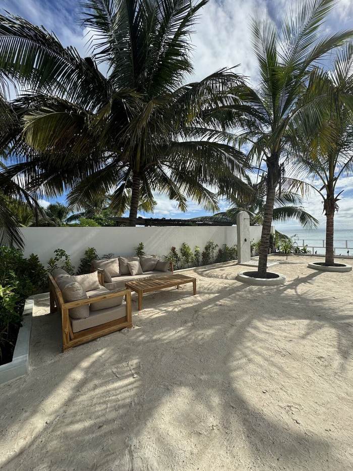 Lounge area on the sand under palm trees